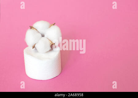 Wattepads zum Entfernen Make-up mit Baumwolle Blume auf der rosa Hintergrund. Stockfoto