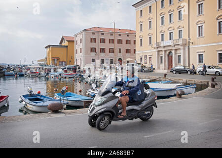 Ein Mann mittleren Alters auf drei Rädern Motorrad Fahrten entlang der adriatischen Küste in Piran, Slowenien. Stockfoto