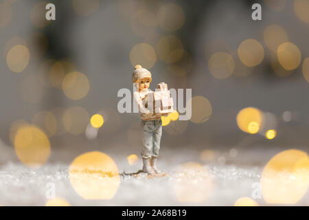 Die dekorativen Weihnachts-themed Figuren. Statue eines Mädchens holding Kartons mit Geschenken für Weihnachten in ihren Händen. Weihnachtsdekoration. Festliche Dez Stockfoto