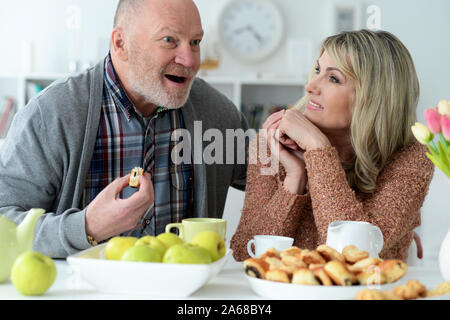 Gerne älteres Ehepaar am Küchentisch sitzen Stockfoto