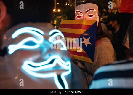 Eine Demonstrantin mit einer Maske hält eine katalanische Unabhängigkeit Estelada Flagge während der Hongkong Katalonien Solidarität Versammlung an der zentralen Bezirk in Hongkong. Stockfoto