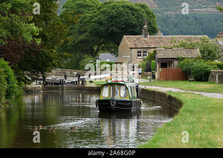 15-04 (schmale Boot) segeln am malerischen ländlichen Leeds Liverpool Canal, 1 Mann auf Stern (Lock & Tore darüber hinaus) - North Yorkshire, England, UK. Stockfoto