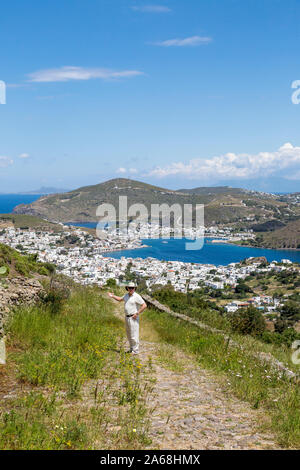 Ältere Menschen wandern auf der Insel Patmos, in Griechenland, mit Blick auf die Skala der Adria und der Port auf einem Hügel über. Stockfoto