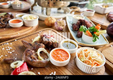 Lamm Zunge Kebab mit Sauerkraut und zwei Saucen. Grill Restaurant Menü. Viele verschiedene Lebensmittel auf dem Tisch. Dinner Party oder Bankett Stockfoto