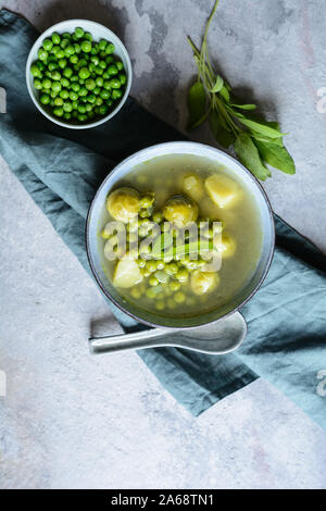 Leichte Mahlzeit, Rosenkohl und Erbsensuppe mit Kartoffeln in einer Keramikplatte Stockfoto