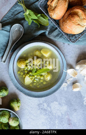 Leichte Mahlzeit, Rosenkohl und Erbsensuppe mit Kartoffeln in einer Keramikplatte Stockfoto