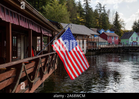 Ketchikan, Alaska, United States - 26. September 2019: Schöne Aussicht auf eine amerikanische Flagge in einem berühmten Creek Street in einer kleinen touristischen Stadt auf der Oc Stockfoto