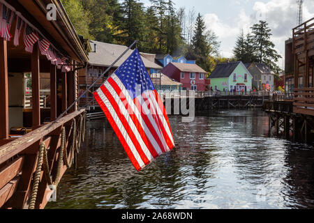 Ketchikan, Alaska, United States - 26. September 2019: Schöne Aussicht auf eine amerikanische Flagge in einem berühmten Creek Street in einer kleinen touristischen Stadt auf der Oc Stockfoto