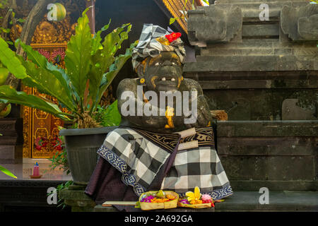 Ein Buddha Statue in den zeremoniellen Tüchern am Eingang des hinduistischen Tempel auf Bali gekleidet Stockfoto