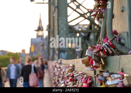 Spaziergang Gruppe von Master Key und unscharfe Menge von Leuten auf Fußgängerweg neben Struktur der Hohenzollernbrücke und Hintergrund der Kölner Dom Stockfoto