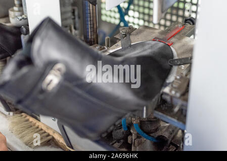 Bildet den vorderen Teil auf einer speziellen Maschine. Schuhproduktion. Stockfoto
