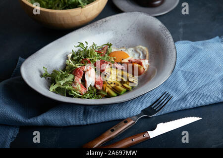 Mittelmeer Salat mit gegrillten Garnelen, Krabben, Cherry Tomaten, Rucola, Grüns, Avocado, Kalk, Oliven, Balsamico Sauce Stockfoto
