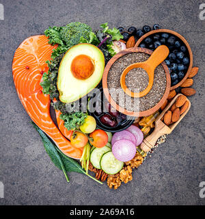 Herz Form der ketogenic Low Carbs Diät Konzept. Zutaten für gesunde Lebensmittel Auswahl auf dunklem Stein Hintergrund. Ausgewogene Zutaten der uns Stockfoto