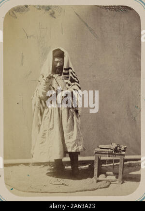 Zeravshan Okrug Samarkand ein jüdischer Mann, trug einen Gebetsschal und wickelt seinen Arm in Phylactery, in Vorbereitung für das Gebet Stockfoto
