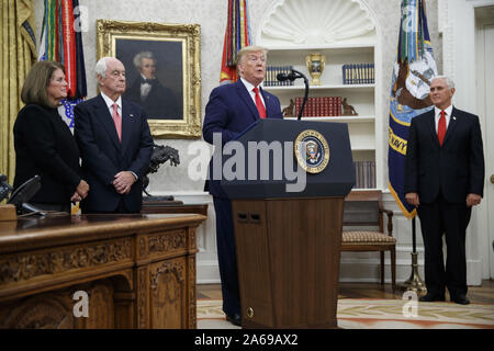 Washington DC, USA. 24. Okt 2019. US-Präsident Donald J. Trumpf (2-R), mit Vice President Mike Pence (R), American Racing Magnat Roger Penske (2-L) und seine Frau Kathy Penske (L), liefert Erläuterungen während der Presidential Medal of Freedom Zeremonie im Oval Office des Weißen Hauses in Washington, DC, USA, 24. Oktober 2019. Credit: ZUMA Press, Inc./Alamy leben Nachrichten Stockfoto