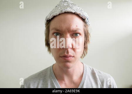 Gesicht der jungen Mann mit Alufolie hat im Zimmer Stockfoto