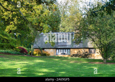 Reetdachhaus und Bäume im Herbst bei Batsford Arboretum, Cotswolds, Moreton-in-Marsh, Gloucestershire, England Stockfoto