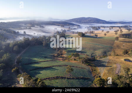 Luftaufnahme über einen Morgen, Nebel und Landschaft Landschaft. Schöne Felder bei Sonnenaufgang Stockfoto