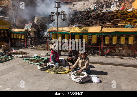 Anbieter Räucherstäbchen verkaufen auf der Straße vor einem Schrein auf den Rundwegen im Stromkreis oder kora Um den Potala Palast in Lhasa, Tibet. Stockfoto