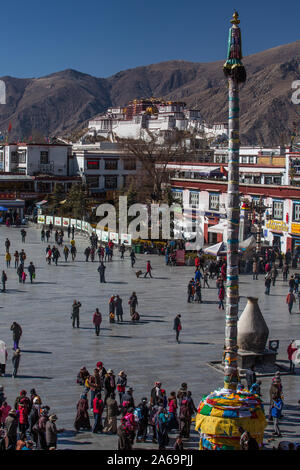 Tibetischen pilgern umrunden um den Jokhang Tempel in Barkhor in Lhasa, Tibet. Im Hintergrund ist der Potala-Palast. Stockfoto