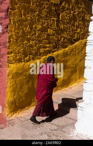 Ein buddhistischer Mönch geht die gelbe Serdung Lhakhang Gebäude des Klosters Ganden auf Wangbur Mountain in Tibet. Stockfoto