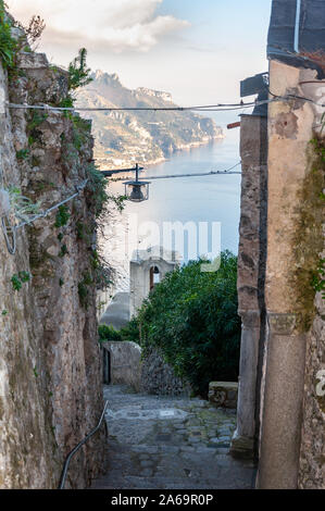 Ravello, an der Amalfi Küste. Fußgängerzone, die auf das Meer und Amalfi absteigt, mit Details der Kirche "Santa Maria delle Grazie". Stockfoto