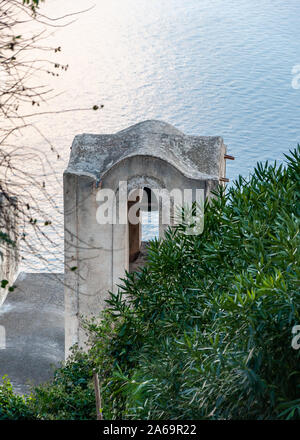 Ravello, an der Amalfi Küste. Fußgängerzone, die auf das Meer und Amalfi absteigt, mit Details der Kirche "Santa Maria delle Grazie". Stockfoto