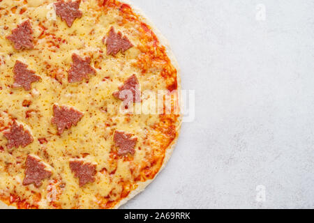 Die Hälfte eines Weihnachten Pepperoni Pizza mit Tannen eingerichtet. Ansicht von oben. Kopieren Sie Platz. Stockfoto