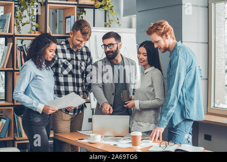 Startupers zusammen arbeiten im Büro stehen Chef am Laptop erklären, Strategie, während Mitarbeiter am Bildschirm lächelte freudig zeigen Stockfoto