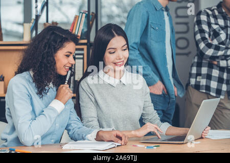 Startupers zusammen arbeiten im Büro Frauen am Tisch sitzen surfen Laptop konzentriert freudige Stockfoto