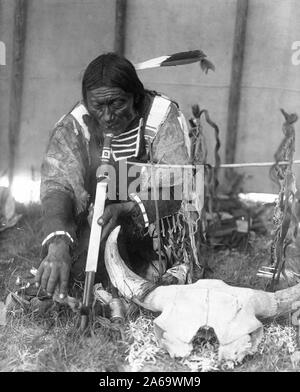 Edward S. Curtis Native American Indians - Dakota Mann mit Calumet kniend von Altar innerhalb des tipi Ca. 1907 Stockfoto