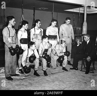 Man sprach mit einer Gruppe von Boxer in einem Boxing Gym, möglicherweise ein Trainer kann. 1936 Stockfoto