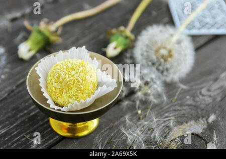 Vegan raw Kugeln mit Cashew Nüsse, Datteln, Kokos und orange. Frische Nein - Backen, Dessert auf Holztisch mit Sommerblumen. Stockfoto