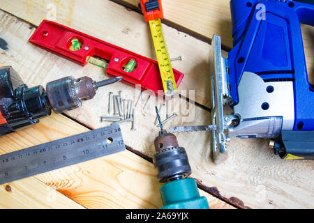 Elektrische Bohrmaschine, Mutter, Maßband, elektrische Säge, Lineal, Werkzeuge für die Holzbearbeitung Konzept Baumaschinen Stockfoto