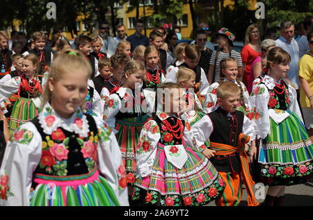 Kinder und andere Personen in traditionellen Trachten aus Lowicz region März in der Straße während der jährlichen Corpus Christi holiday Feier. Stockfoto