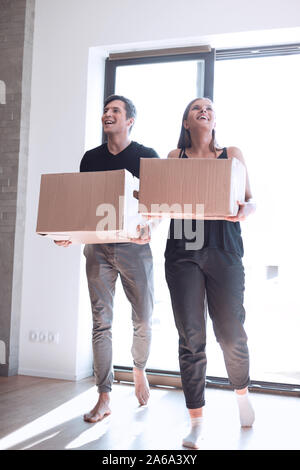 Glückliches junges Paar trägt große Kartons. Stockfoto