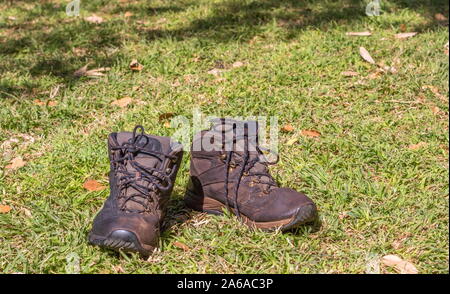 Ein paar alte verwitterte braune Leder Herren stiefel auf einem Patch von Gras Bild mit Kopie Raum im Querformat isoliert Stockfoto