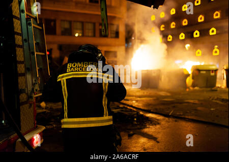 Barcelona, Spanien - 19. Oktober 2019: ein Feuerwehrmann nachts mit Feuer im Hintergrund, die in eine gefährliche Situation während der katalanischen Unruhen mit Po Stockfoto