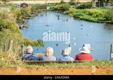 Ältere Menschen genießen die Ruhe der Blakeney Erhaltung Duck Pond in der Nähe der North Norfolk Coast in East Anglia, England, UK. Stockfoto