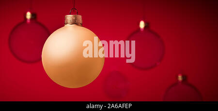 Golden christmas Ball vor Glas Weihnachtskugeln rot studio Hintergrund. Für die Grußkarte oder Design Vorlage. Mit spa Kopieren Stockfoto