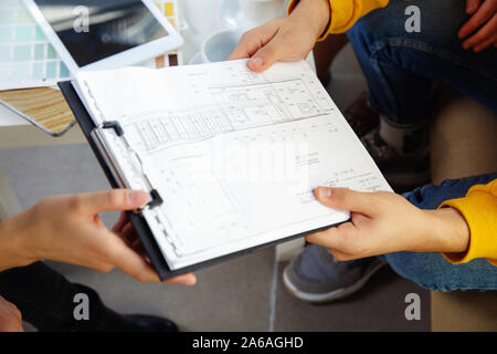 Interior Designer arbeiten mit jungen Paar. Sehr nette Familie und professionellen Designer oder conept architector Erörterung künftiger Innenraum, Arbeiten mit Farbpalette, Zimmer Zeichnungen in modernen Büro. Stockfoto