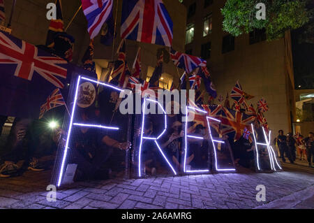 Maskierte Demonstranten mit britischen Flaggen bilden eine Menschenkette vor dem britischen Konsulat in Hongkong. Sie fordern die britische Regierung die Debatte über die zweite Staatsbürgerschaft des House of Lords für Hongkong zu unterstützen. Hong Kong, 23.10.2019 | Verwendung weltweit Stockfoto