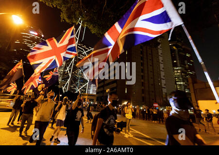 Maskierte Demonstranten mit britischen Flaggen bilden eine Menschenkette vor dem britischen Konsulat in Hongkong. Sie fordern die britische Regierung die Debatte über die zweite Staatsbürgerschaft des House of Lords für Hongkong zu unterstützen. Hong Kong, 23.10.2019 | Verwendung weltweit Stockfoto