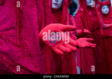 Aussterben Rebellion Klimawandel Aktivist performance art Truppe der Roten Rebellen Brigade tragen helle rote Kostüme März still in der Bank, im Herzen der City von London Financial District am 14. Oktober 2019 in London, England, Vereinigtes Königreich. Aussterben Rebellion ist ein Klimawandel Gruppe begann im Jahr 2018 und hat eine riesige Fangemeinde von Leuten zu friedlichen Protesten begangen. Diese Proteste sind die Hervorhebung, dass die Regierung nicht genug um die katastrophalen Klimawandel zu vermeiden und zu verlangen, dass sie die Regierung radikale Maßnahmen zu ergreifen, um den Planeten zu retten. Stockfoto