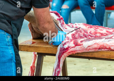 Schlachtung und traditionelle Herstellung der iberischen Schwein und extrahieren Sie verschiedene Teile der Iberischen Schwein 2019 iberischer Schinken Messe von Aracena Stockfoto