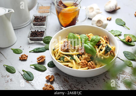 Pasta Bucatini in Sahnesauce mit frischen Spinat, Knoblauch, Brötchen a'la Huhn, Feta und Walnüsse Stockfoto