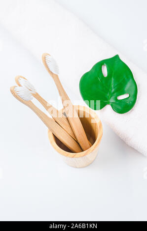 Bambus Zahnbürsten in Holz Glas mit Handtuch. Umweltfreundliches Konzept. Stockfoto