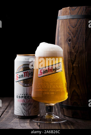 LONDON, Großbritannien - 27 April, 2018: Aluminium und original Glas San Miguel Lagerbier neben Holzfass. Die San Miguel Bier der Marke ist der Leitung Stockfoto