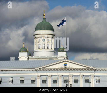 flattern Nationalflagge Finnlands gegen Dom von Helsinki, prominentesten Gebäude und Wahrzeichen der Stadt Stockfoto