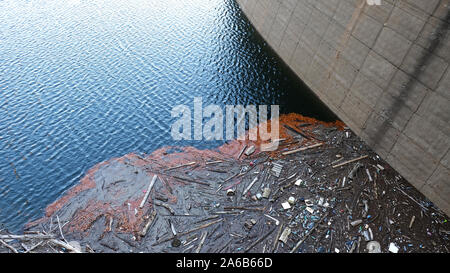 Vidraru Dam, Rumänien - Oktober 12, 2019: Kunststoff Verunreinigungen am Rand des Vidraru See in Arges in Rumänien und kontrastieren mit dem klaren, blauen Wasser o Stockfoto